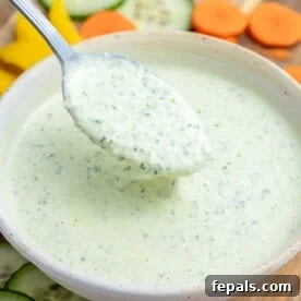 a spoon full of green goddess dressing from a bowl.