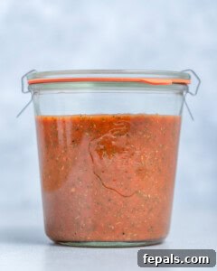 A jar of homemade pizza sauce ready for storage.