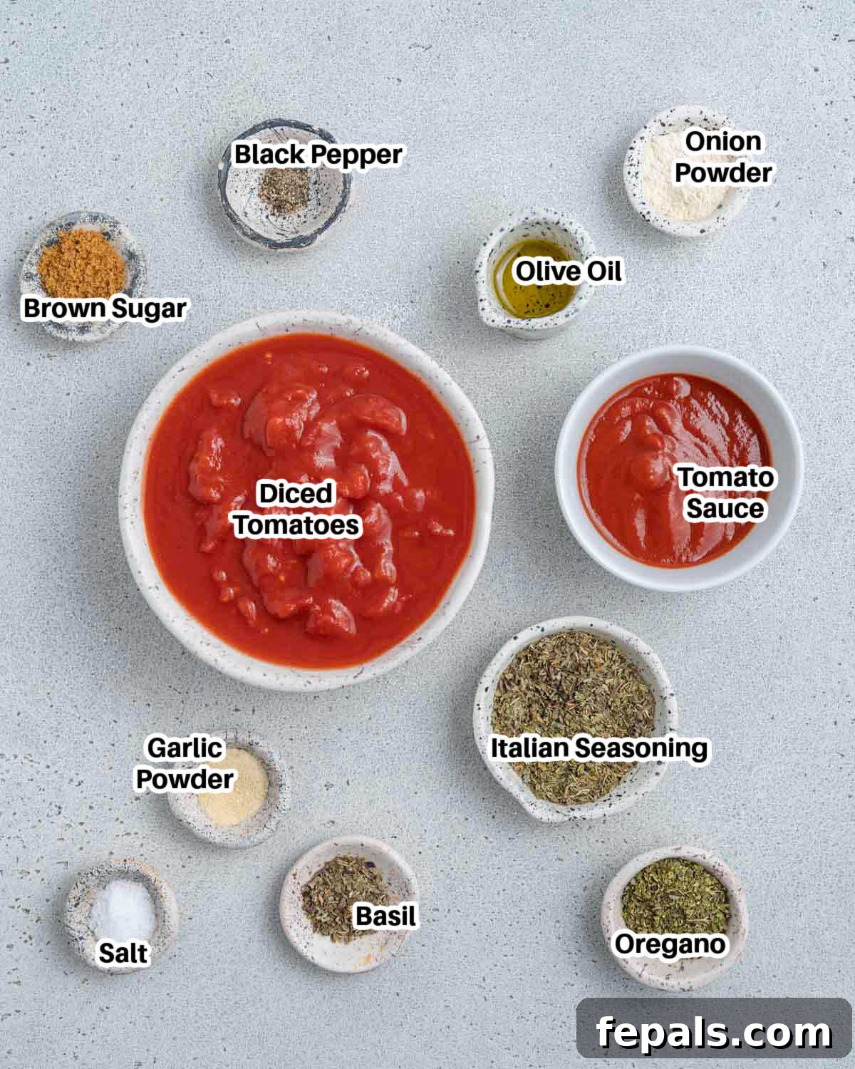 A visual spread of fresh ingredients laid out on a table, including canned tomatoes, herbs, garlic, and olive oil, ready for making homemade pizza sauce.