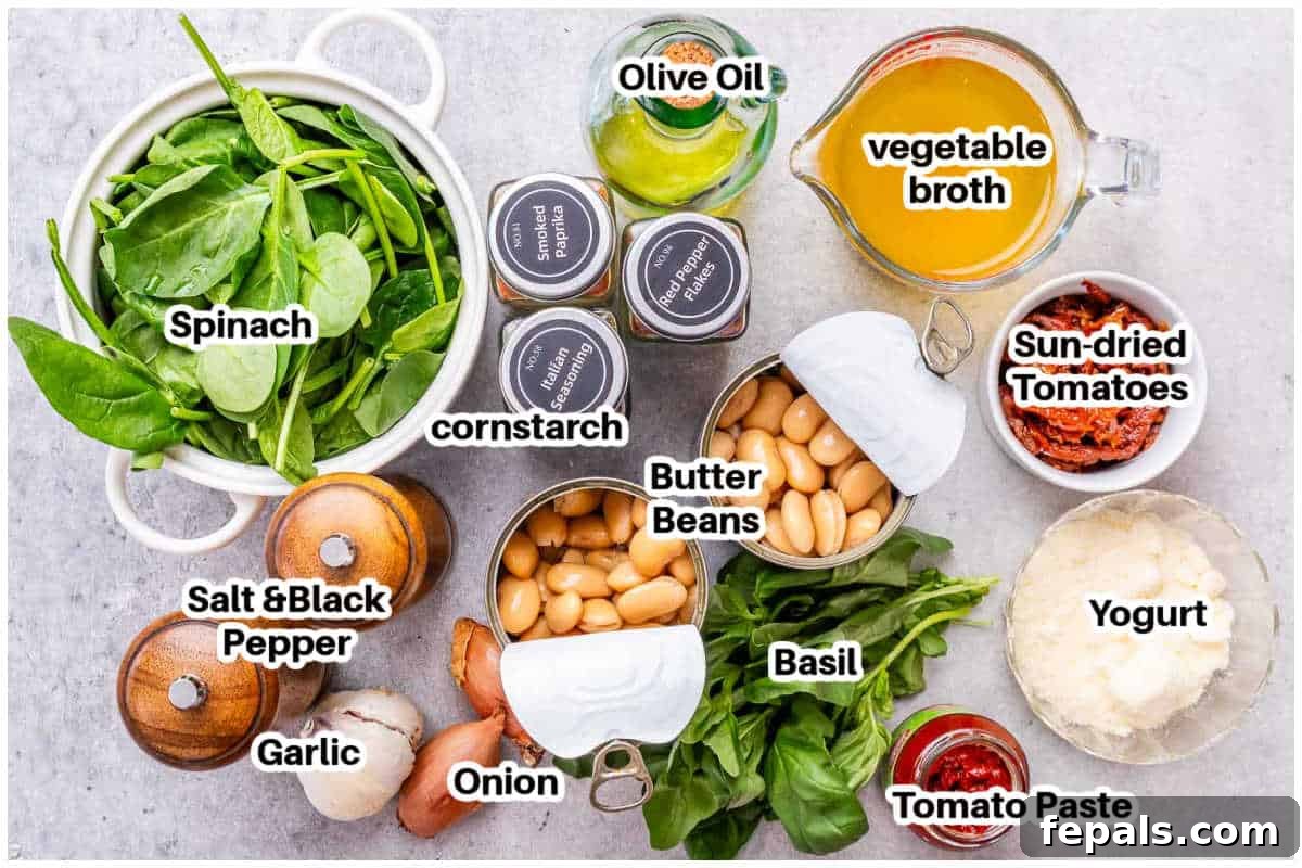 The Butter Bean Proposal 3 A flat lay of fresh ingredients for Marry Me Butter Beans, including sun-dried tomatoes, shallots, garlic, spices, canned butter beans, spinach, and a container of Greek yogurt.
