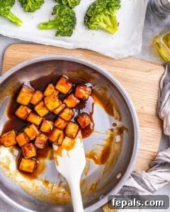 Cooking the tofu in a pan with teriyaki sauce.