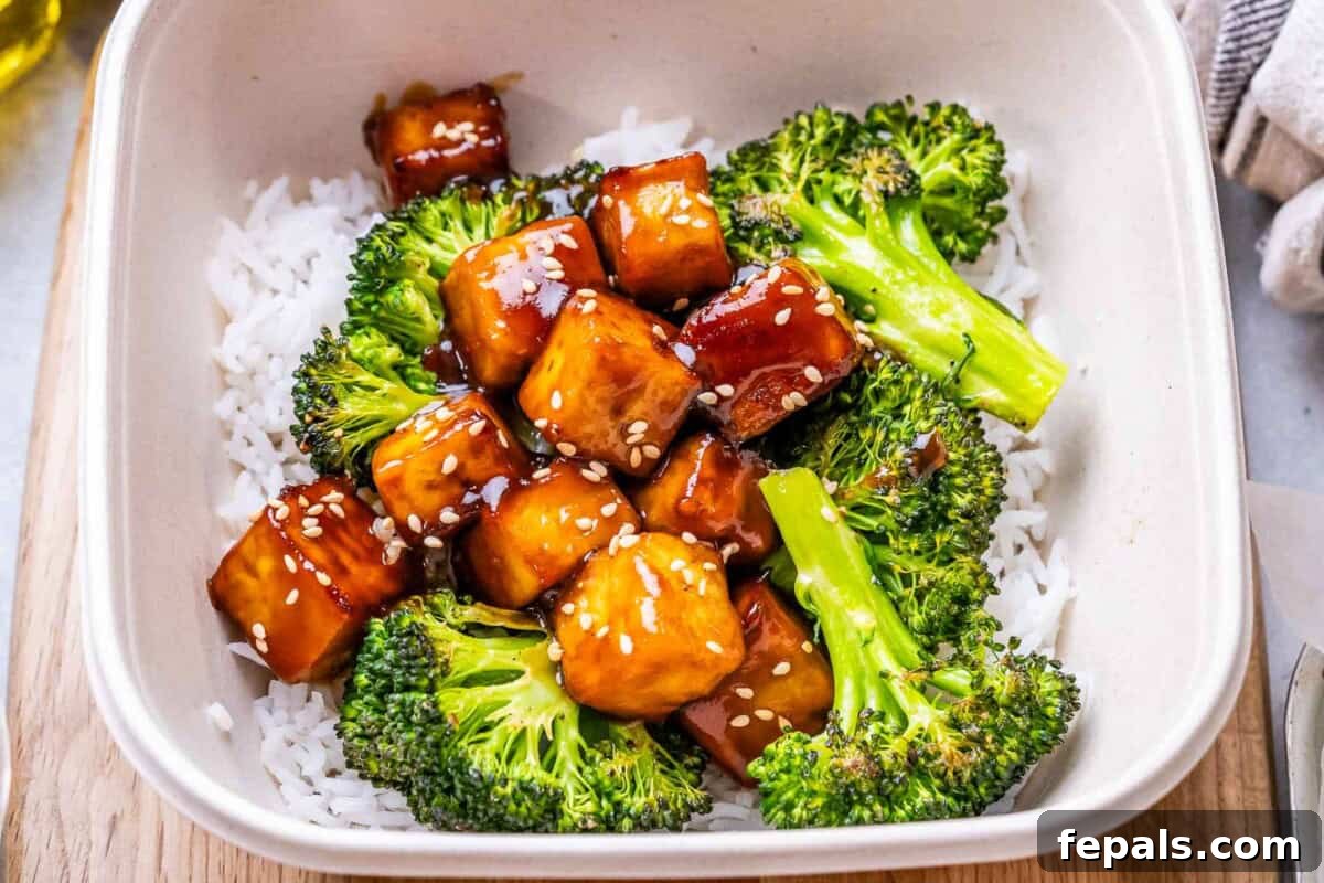 No-Fuss Teriyaki Tofu 6 A vibrant white bowl filled with teriyaki tofu, roasted broccoli, and white rice, ready to be enjoyed as a healthy and flavorful meal.