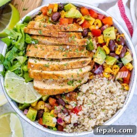 Top view of a delightful taco grilled chicken bowl, featuring seasoned grilled chicken, fresh salad greens, and wholesome quinoa in a white bowl.