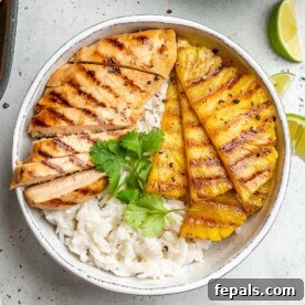 Top view of a tropical Hawaiian grilled chicken bowl, served over rice with juicy grilled chicken and sweet pineapple chunks.