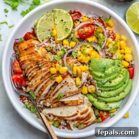 Top-down view of a vibrant Mexican grilled chicken bowl, featuring perfectly grilled chicken, sliced avocado, sweet corn, and quinoa, creating a colorful and flavorful dish.