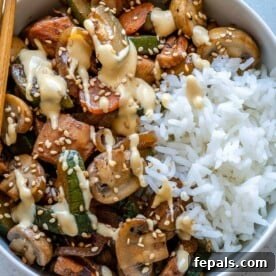 Top view and close-up of a delightful hibachi chicken rice bowl, showcasing tender chicken pieces, assorted vegetables, and perfectly cooked rice.