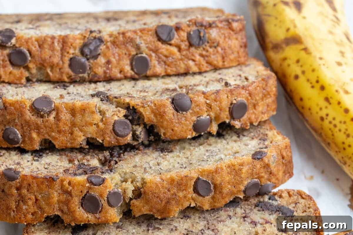 Nutty Browned Butter Banana Loaf 6 Several slices of moist browned butter banana bread stacked on top of each other, showcasing its tender texture and chocolate chips.