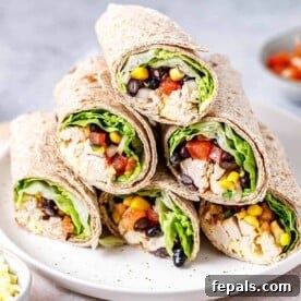 A side shot of perfectly halved Southwest chicken wraps, revealing their colorful and fresh filling, arranged neatly on a plate.