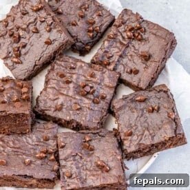 Perfectly cut brownie square bars, rich and fudgy, presented on a round white plate.