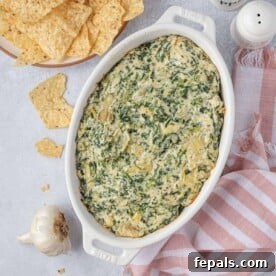 Top view of a bubbling hot spinach and artichoke dip in a rustic dish, ready to be enjoyed.