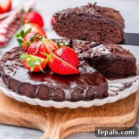 Valentine's Day Recipes for Grown-Ups 22 Chocolate cake on a plate top with melted chocolate and strawberries.