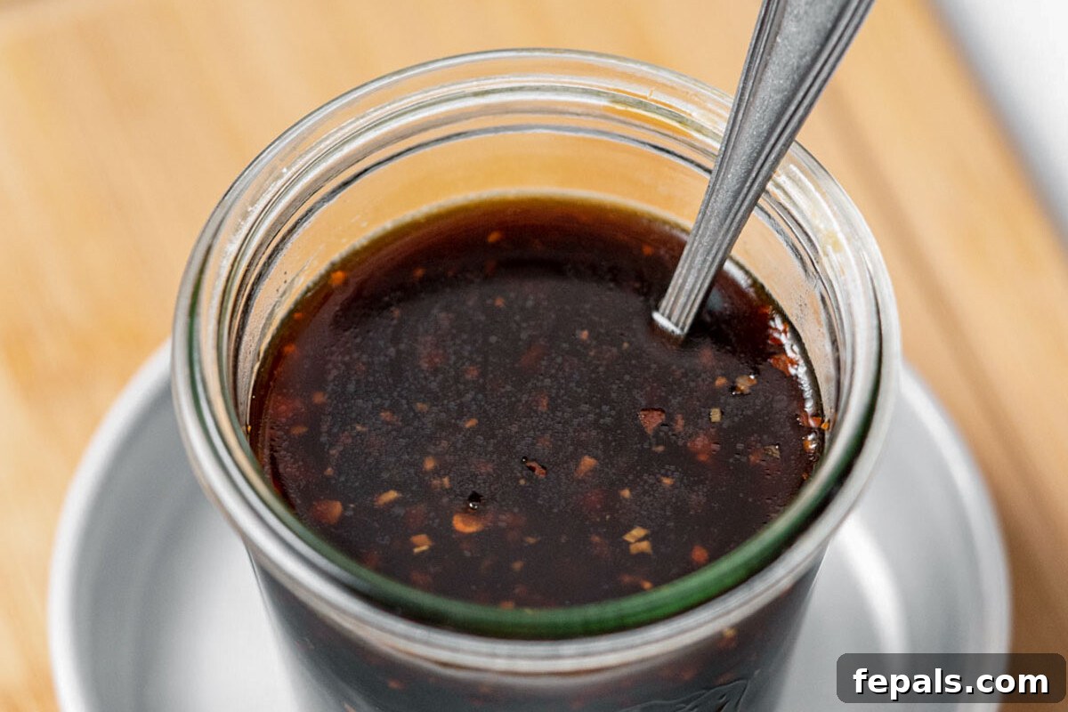 Your Own Signature Teriyaki Sauce 5 A jar filled with fresh homemade teriyaki sauce, garnished with sesame seeds, ready for use.