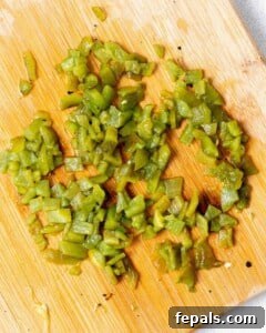Peeled and chopped roasted poblano pepper on a cutting board.
