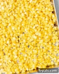 Cooked corn spread on a sheet pan to cool.