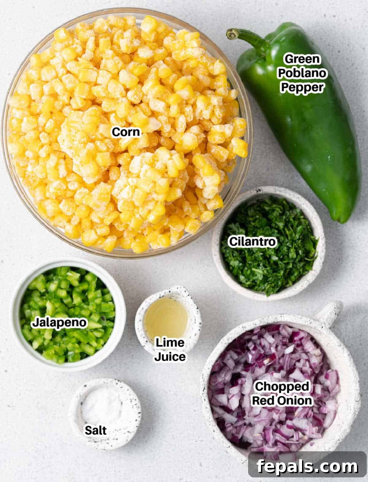 A vibrant selection of ingredients for making homemade Chipotle corn salsa, including corn, poblano, onion, cilantro, and lime.