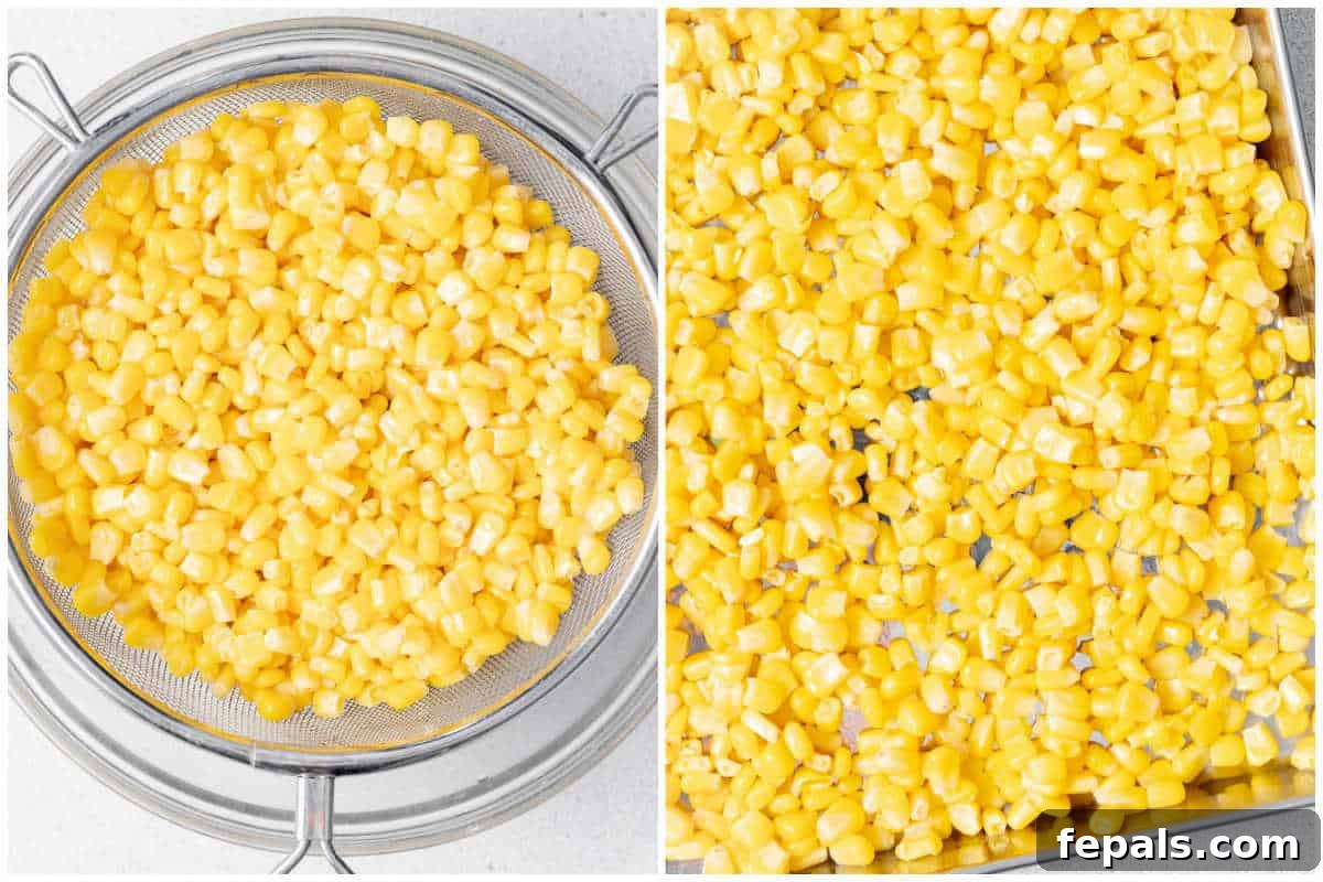 Drained corn kernels cooked and spread over a sheet pan to cool.