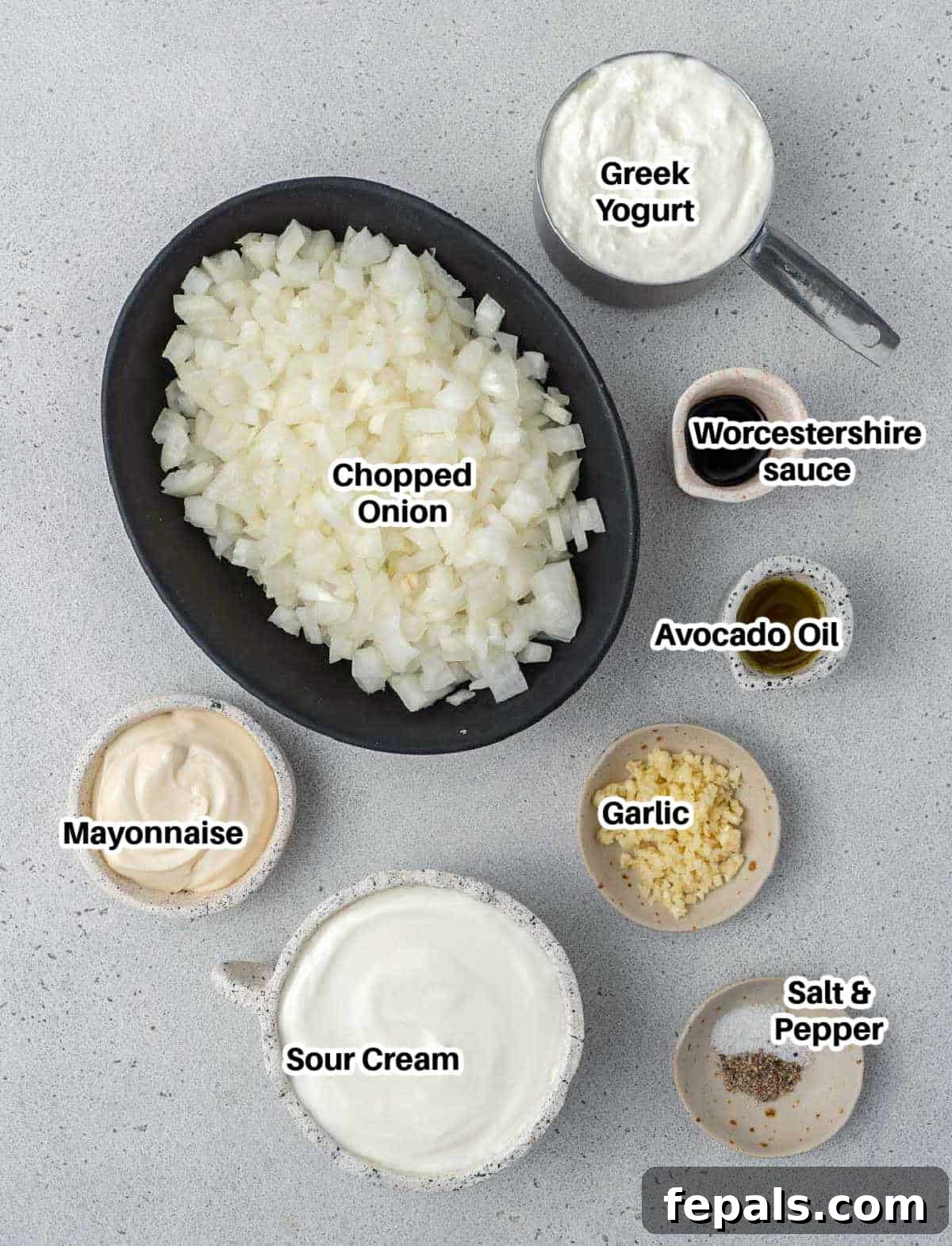 Decadent French Onion Dip 3 A flat lay photograph showcasing all the fresh ingredients needed for French onion dip, neatly arranged.