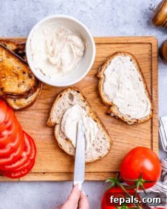 Mayo being spread over toast.