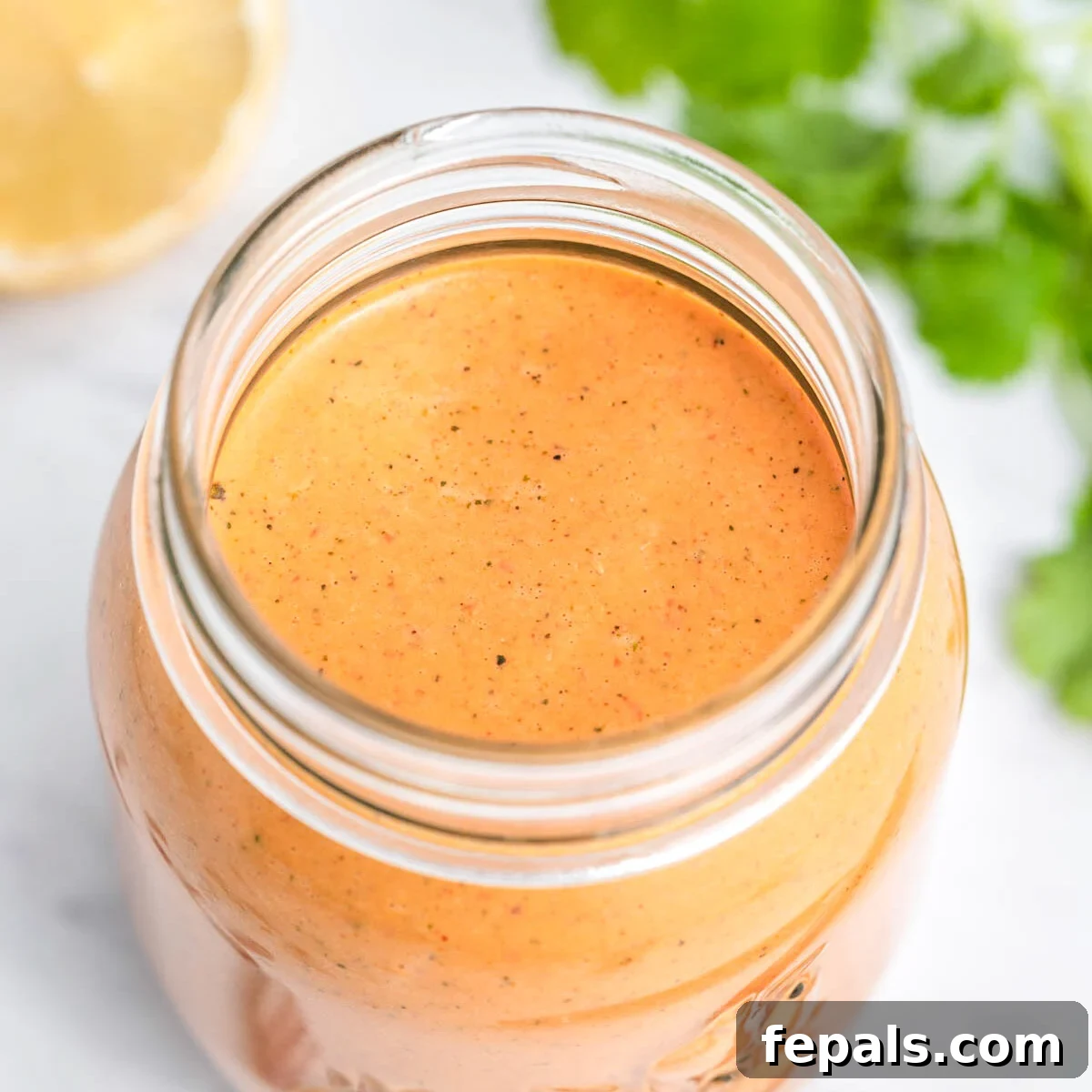 Spicy Homemade Peri Peri Sauce 6 A sealed glass jar filled with vibrant homemade peri peri sauce, ready for storage.