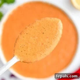 A spoonful of peri peri sauce over a bowl.