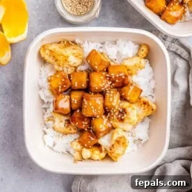 Crispy Orange Tofu 8 a meal prep bowl with crispy orange tofu served with roasted cauliflower over white rice.