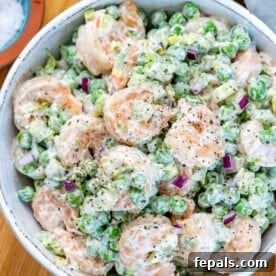 top view creamy shrimp salad with peas and celery in a white bowl