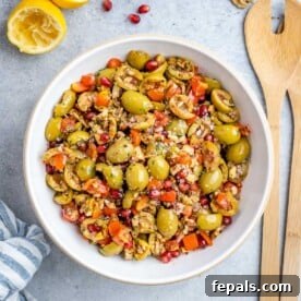 Olive salad fully mixed and ready to serve, with a lemon wedge on the side.