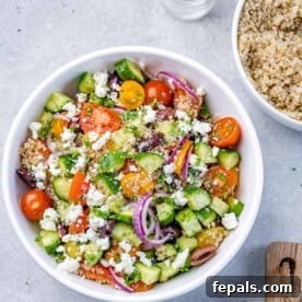 Tossed quinoa salad in circular white bowl.