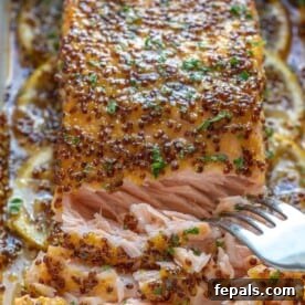 A close-up of beautifully baked salmon, showing the flakes of tender fish, signaling it's perfectly cooked.