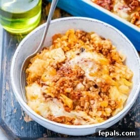 A hearty cabbage roll casserole, featuring layers of rice and seasoned ground beef baked to perfection in a flavorful tomato sauce.