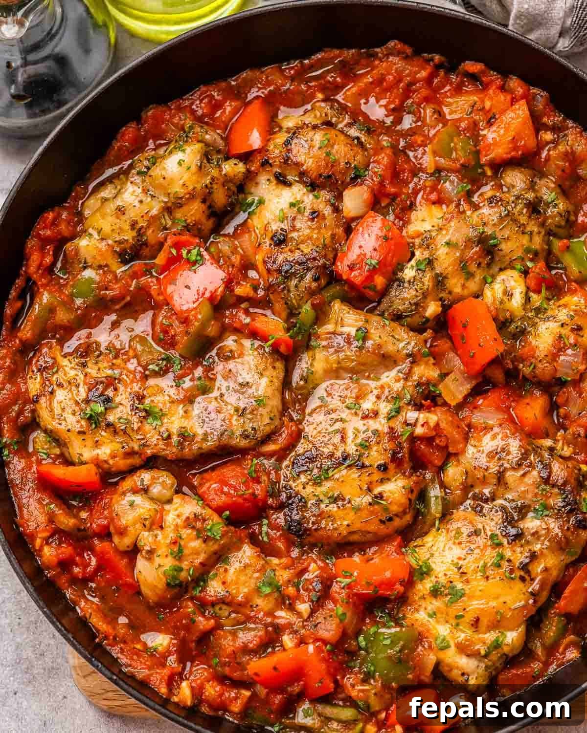 Rustic Hunter's Chicken 2 A skillet with chicken cacciatore made with tender chicken thighs, vibrant tomatoes, onions, and bell peppers.