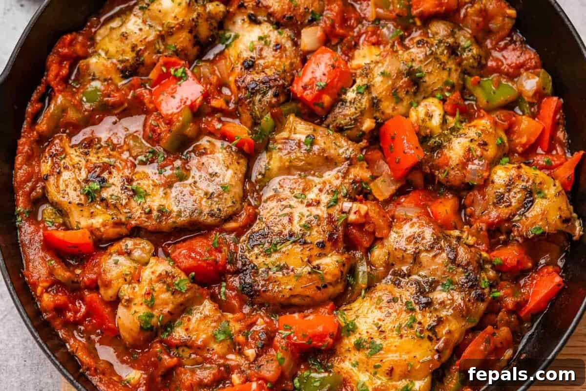 Rustic Hunter's Chicken 8 A hearty portion of Chicken Cacciatore simmering in a black cast-iron skillet, showcasing its rich texture and vibrant colors.