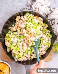 Cooked chicken and sautéed vegetables in a skillet.