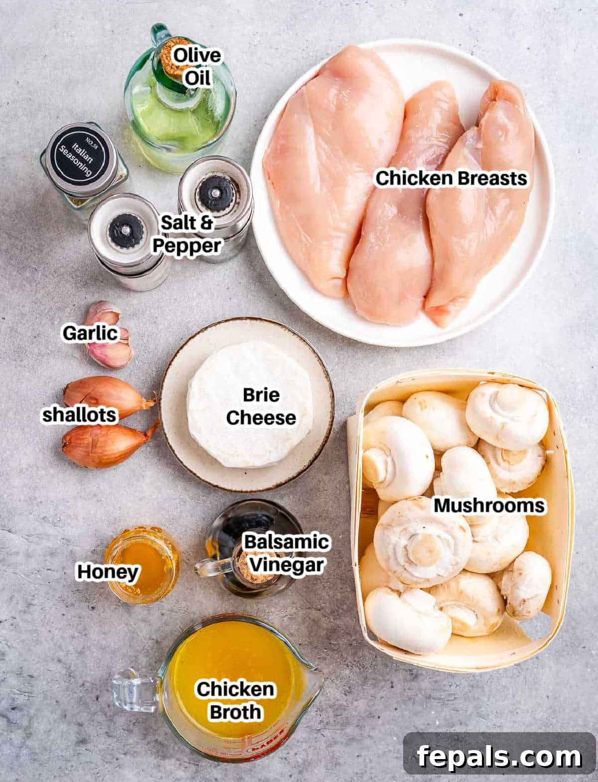A flat lay of fresh ingredients laid out for making stuffed chicken marsala, including chicken breasts, mushrooms, shallots, garlic, cheese, and herbs.