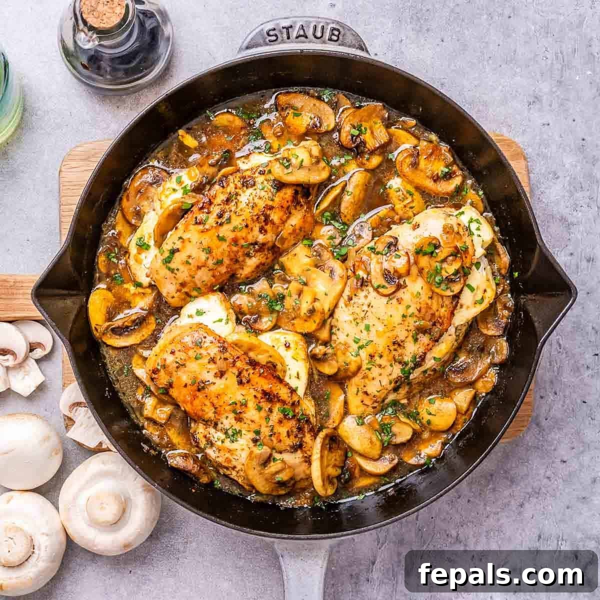 An overhead shot of a skillet filled with four stuffed chicken breasts, golden brown and glistening with rich mushroom Marsala sauce, ready to be served.