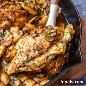 spoon grabbing a serving of stuffed chicken breast with mushrooms.