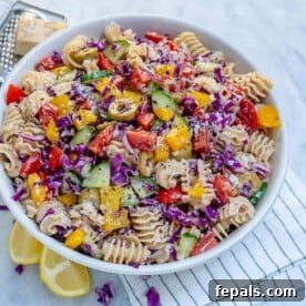 A vibrant vegetarian pasta salad, showcasing a colorful medley of pasta and garden-fresh vegetables in a generous serving bowl.