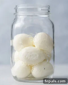 Ruby Red Pickled Eggs 10 Peeled hard-boiled white eggs in a mason jar.