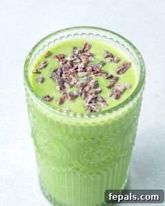 Shamrock shake in a glass topped with cocoa nibs.