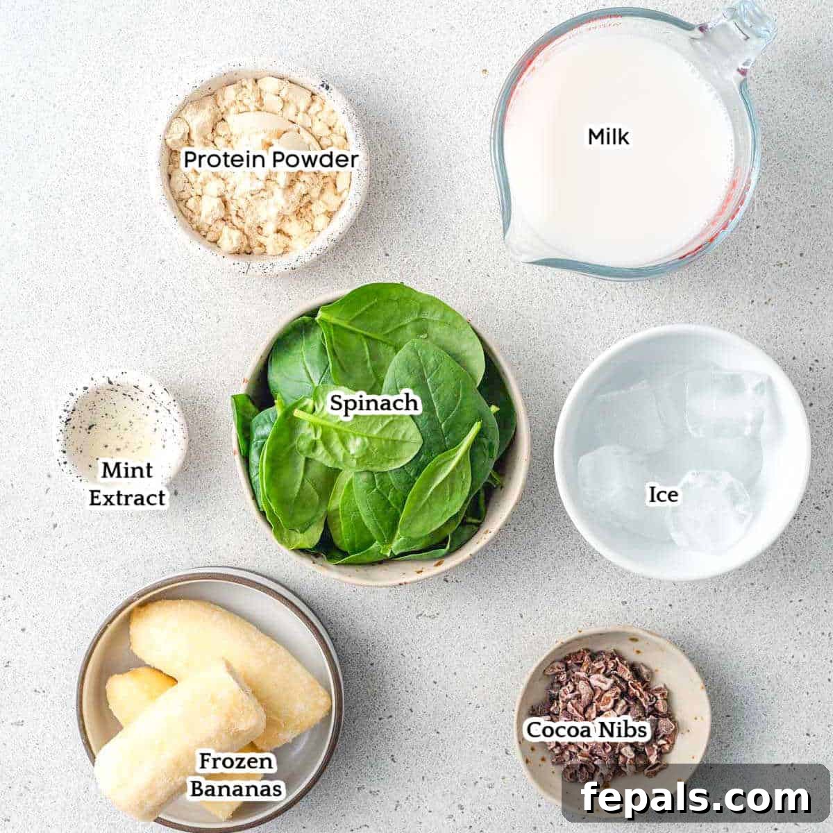 A curated display of all the fresh ingredients needed to blend a healthy and delicious shamrock protein smoothie, including spinach, bananas, and milk.