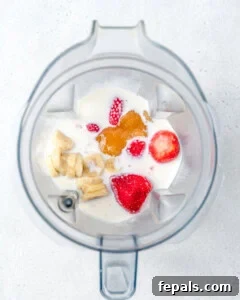 all ingredients for strawberry smoothie added to a blender.