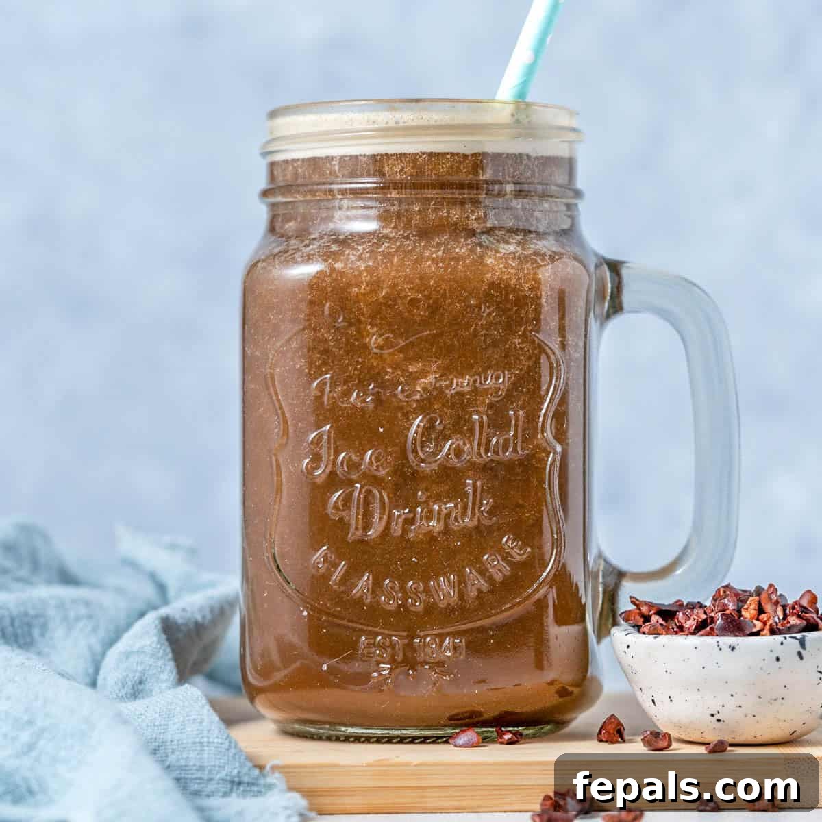 Brewed Protein Fuel 7 A beautifully presented mason jar filled with a creamy coffee protein shake, adorned with a straw and ready to be savored.