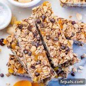 Healthy granola bars with nuts, oats, and chocolate chips stacked over each other.
