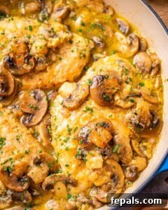 Golden Pan-Seared Chicken Medallions 14 A skillet containing chicken scallopini with mushrooms and sauce.