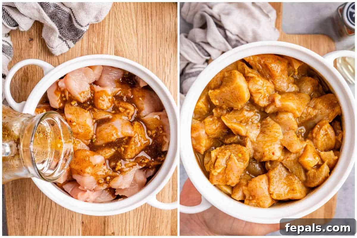 Fiery Goan Chicken Vindaloo 4 Cubed chicken breast soaking in a vibrant reddish-brown marinade in a mixing bowl.
