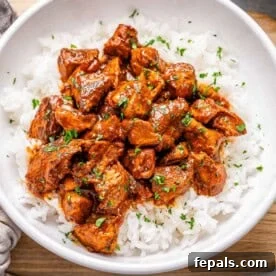 Fiery Goan Chicken Vindaloo 8 Chicken vindaloo served over white rice in a bowl, ready to be eaten.