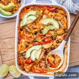 Effortless Cinco De Mayo Feast 11 a spoon in a baking dish with chicken fajita, topped with sliced avocado.
