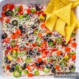 Effortless Cinco De Mayo Feast 18 top view of taco dip in a dish with tortilla chips on the side