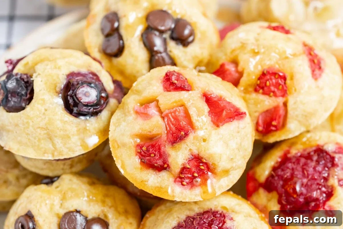 A small bowl overflowing with freshly baked mini muffins, stacked invitingly over each other, highlighting their perfect golden texture.