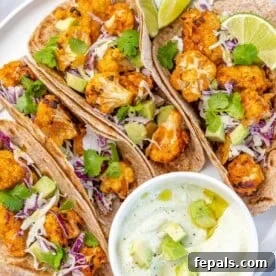 Top-down view of flavorful cauliflower tacos, served with a delicious dipping sauce on the side, perfect for a vegetarian meal.